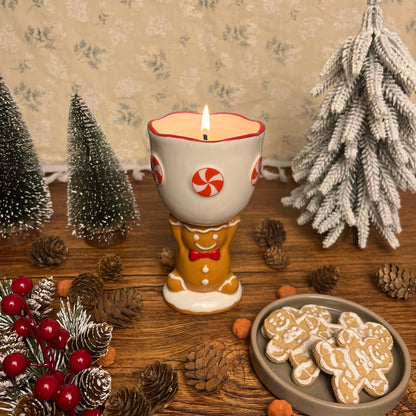 Gingerbread cookie scented ceramic gingerbread goblet candle styled with holiday décor and festive greenery.