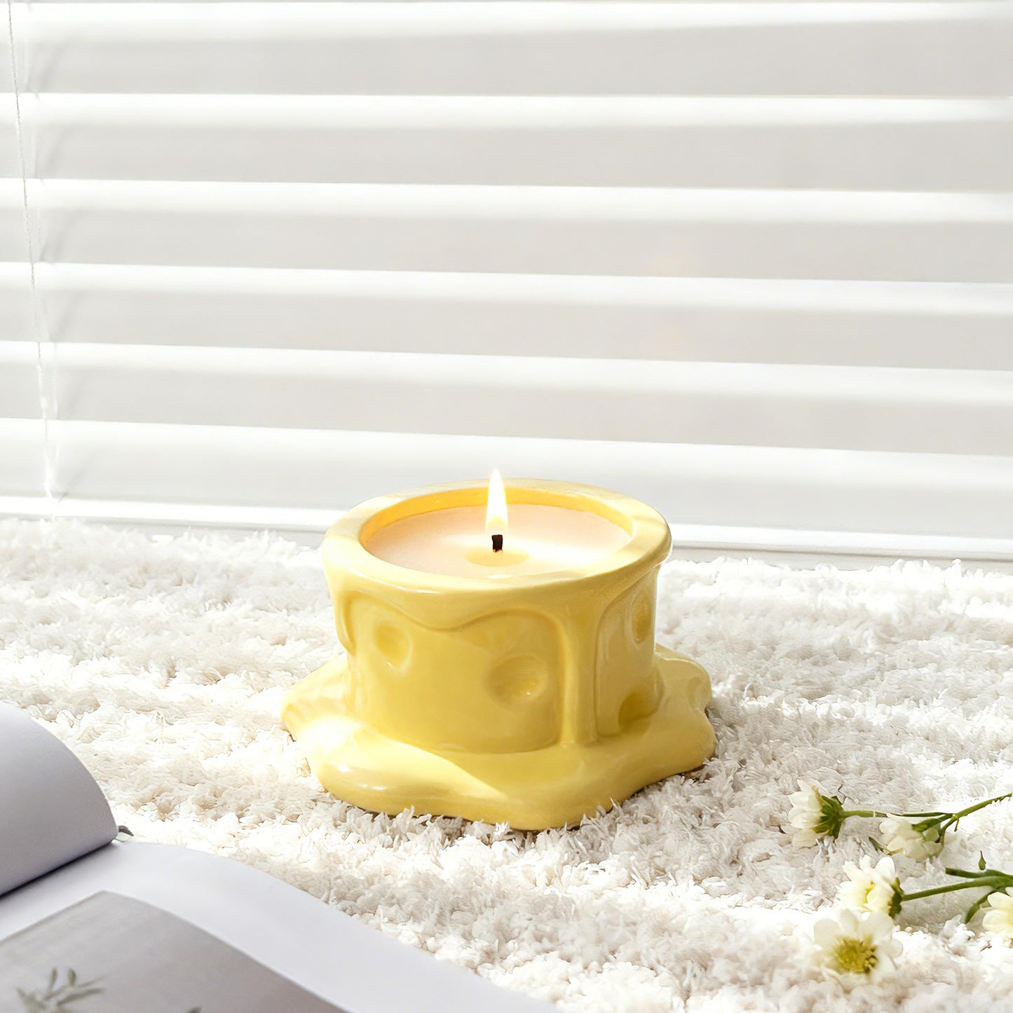 Vanilla cheesecake-scented ceramic soy candle styled on a soft white rug by a window, lit for a cozy home setting.