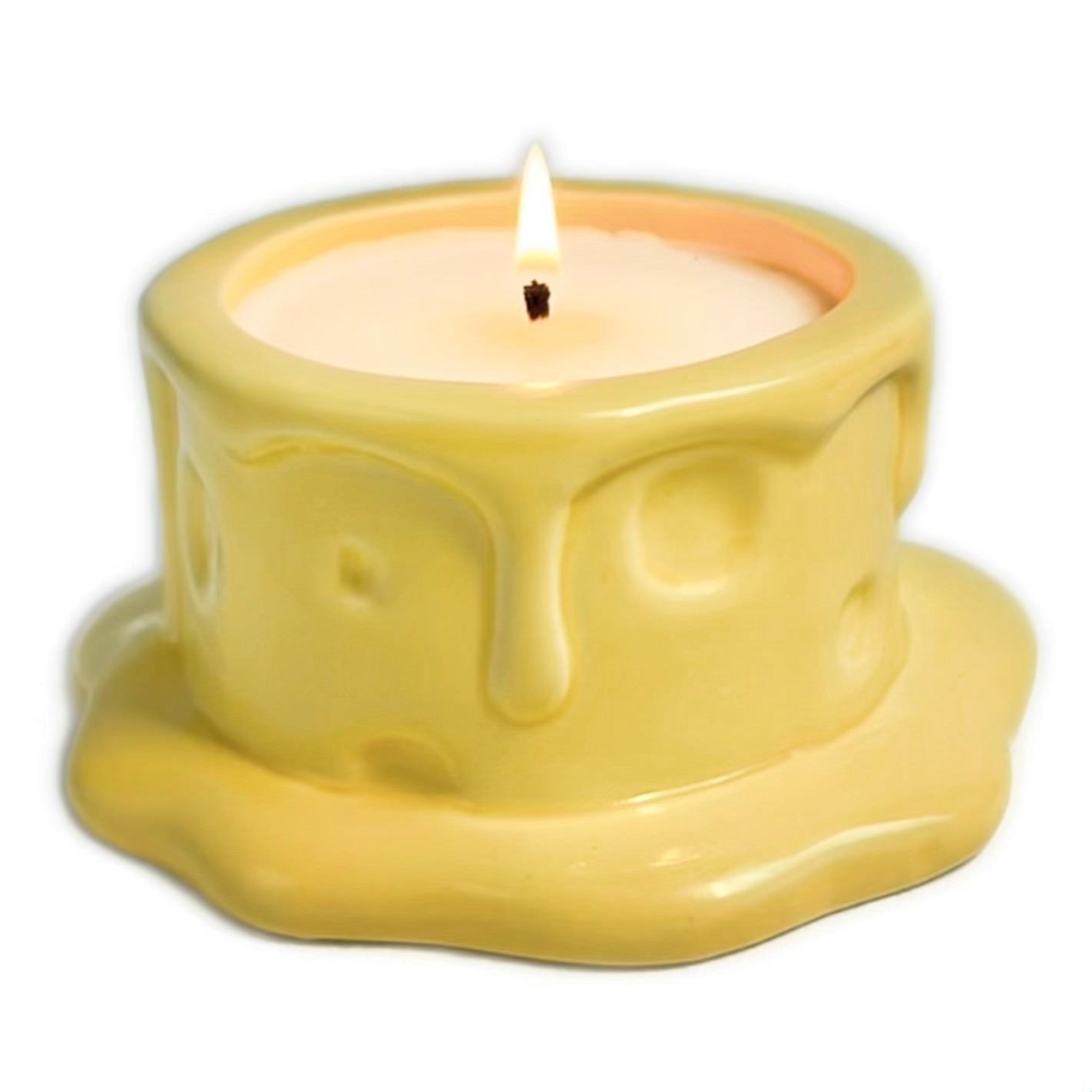 Vanilla cheesecake-scented ceramic soy candle designed like a cheese wheel with dripping glaze, photographed on a white background.